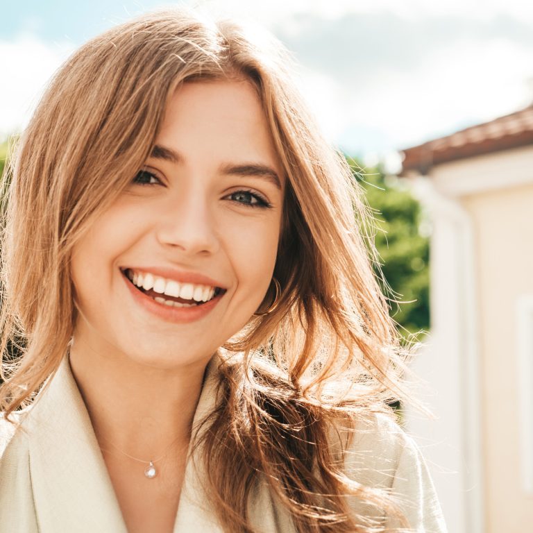 Closeup portrait of beautiful smiling brunette model. Trendy female posing in the street background. Funny and positive woman having fun outdoors Closeup portrait of beautiful smiling brunette model. Trendy female posing in the street background. Funny and positive woman having fun outdoors